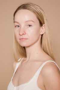 Reading emotions challenge: what does the pictured expression say to you?  A young white woman with long blond hair looks at the camera.